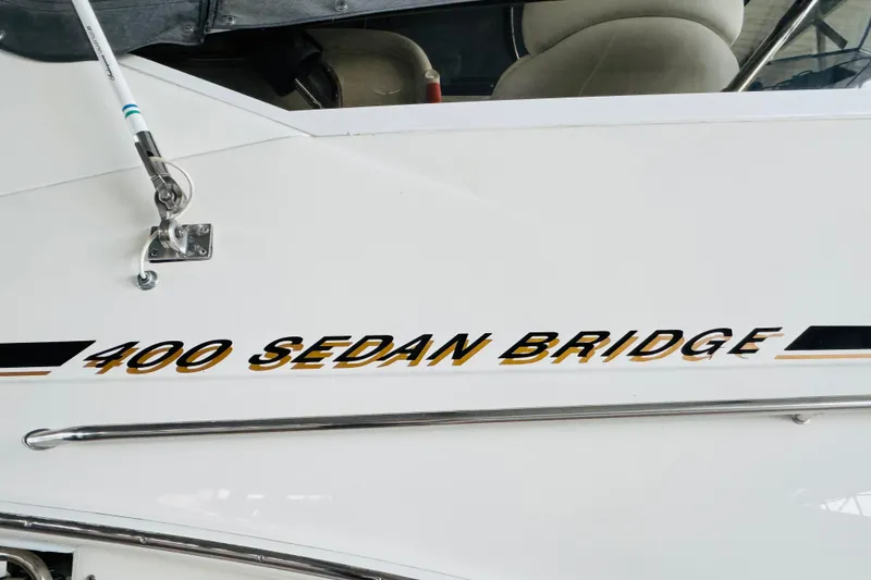 Slide: The Image of 1999 Sea Ray 400 Sedan Bridge boat nameplate on white hull. - 15