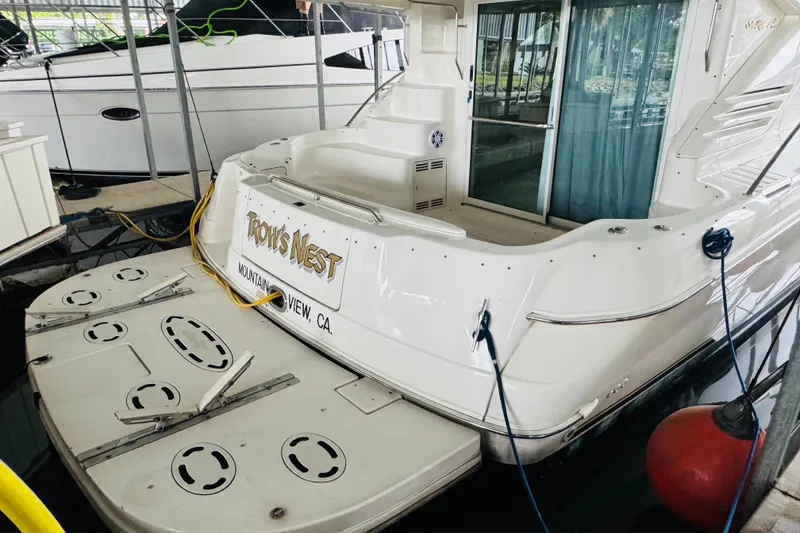 Slide: The Image of 1999 Sea Ray 400 Sedan Bridge docked, rear view with "Troy's Nest" signage. - 18