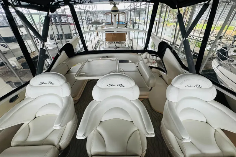 Slide: The Image of Interior view of 1999 Sea Ray 400 Sedan Bridge with white seating and table. - 29