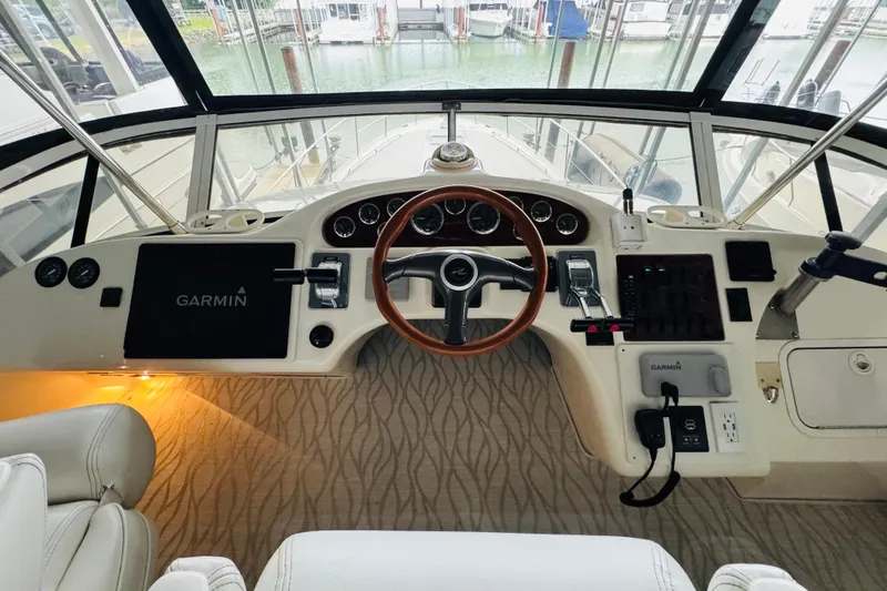 Slide: The Image of 1999 Sea Ray 400 Sedan Bridge helm with Garmin navigation system and elegant wood steering wheel. - 35