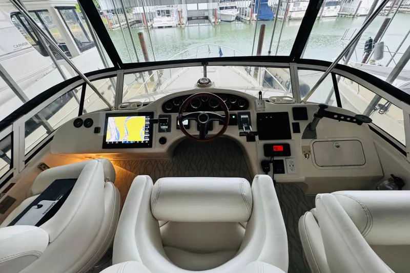 Slide: The Image of 1999 Sea Ray 400 Sedan Bridge helm with modern navigation equipment and luxurious seating. - 36