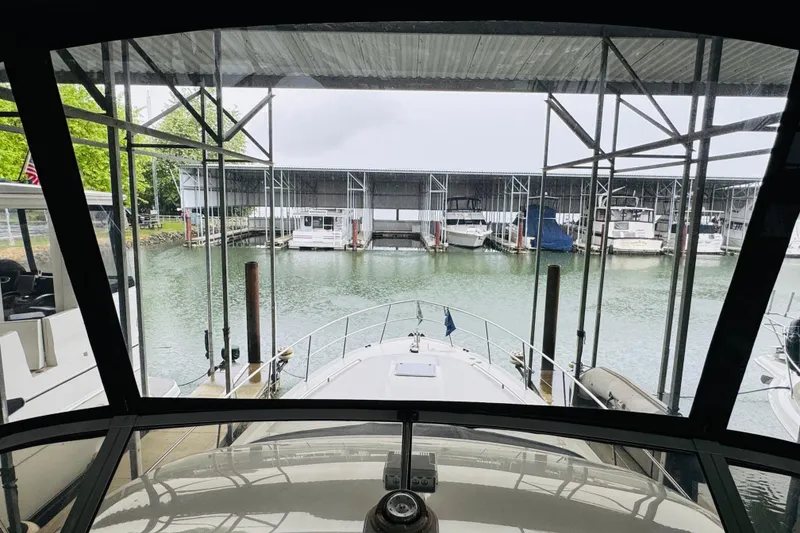 Slide: The Image of 1999 Sea Ray 400 Sedan Bridge docked in a marina, surrounded by other boats. - 54