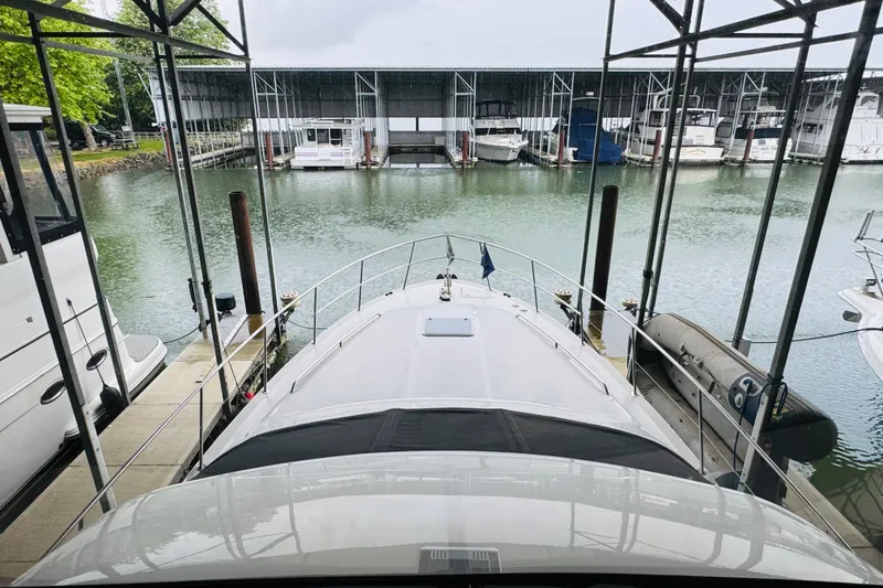 Slide: The Image of 1999 Sea Ray 400 Sedan Bridge docked in a marina with covered slips. - 55