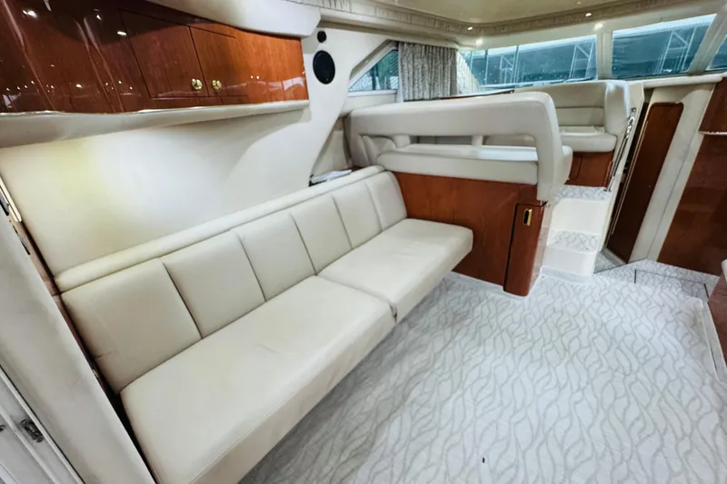 Slide: The Image of Interior of 1999 Sea Ray 400 Sedan Bridge with beige seating and wooden cabinetry. - 57