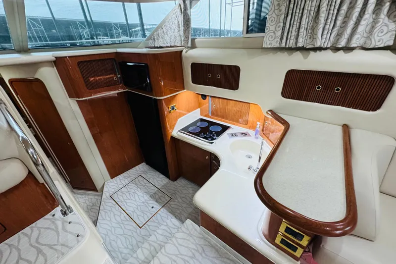 Slide: The Image of 1999 Sea Ray 400 Sedan Bridge yacht interior with kitchenette and wood accents. - 60