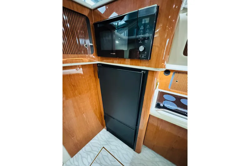 Slide: The Image of 1999 Sea Ray 400 Sedan Bridge kitchen with microwave and refrigerator. - 73