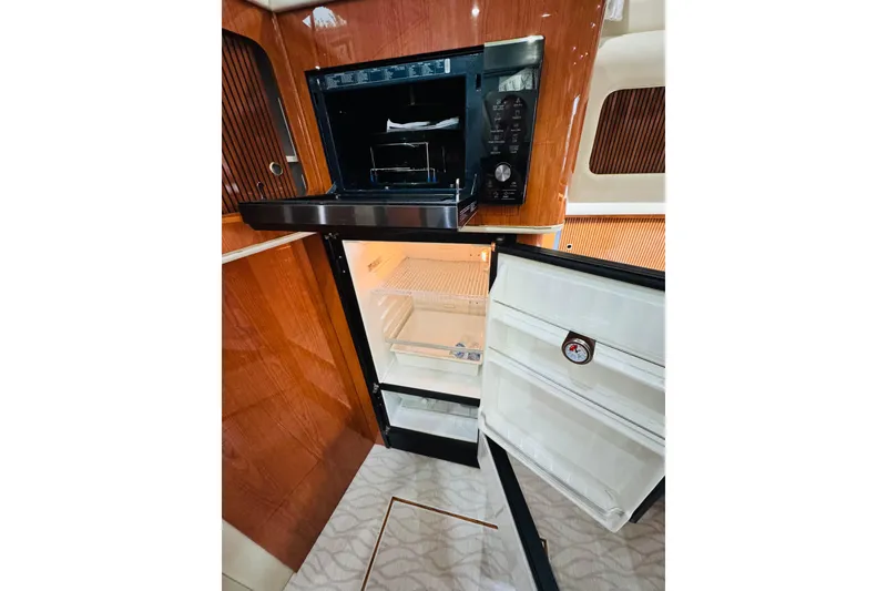 Slide: The Image of 1999 Sea Ray 400 Sedan Bridge yacht kitchen with open fridge and microwave. - 74