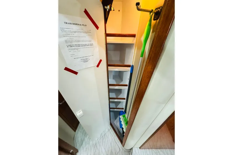 Slide: The Image of 1999 Sea Ray 400 Sedan Bridge interior storage with cleaning supplies and trash disposal plan. - 76