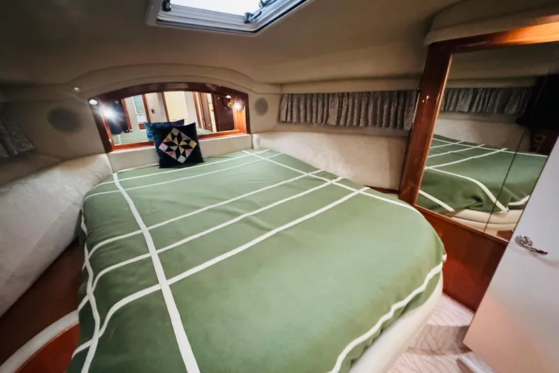 Slide: The Image of Cozy bedroom interior of 1999 Sea Ray 400 Sedan Bridge yacht with green bedding. - 80