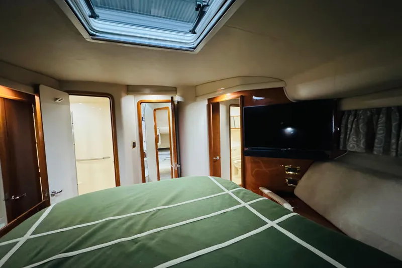 Slide: The Image of Interior of 1999 Sea Ray 400 Sedan Bridge yacht with green bedding and TV. - 81
