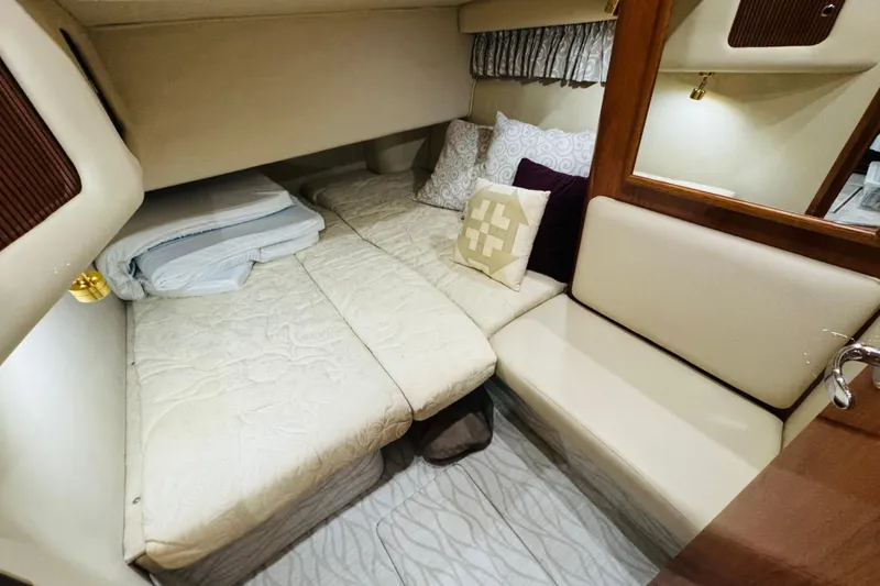 Slide: The Image of 1999 Sea Ray 400 Sedan Bridge cabin interior with cozy bedding and seating area. - 83