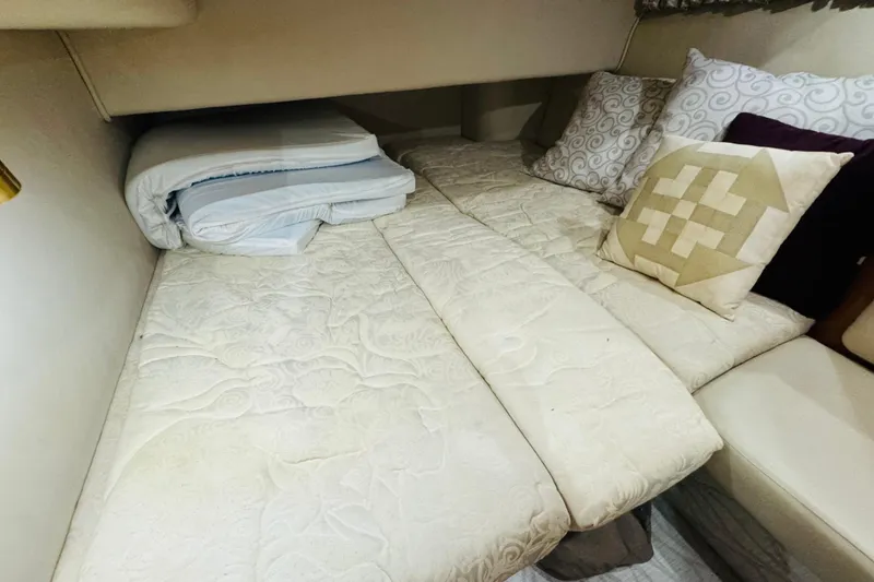 Slide: The Image of Cozy cabin bed with patterned pillows in a 1999 Sea Ray 400 Sedan Bridge. - 84