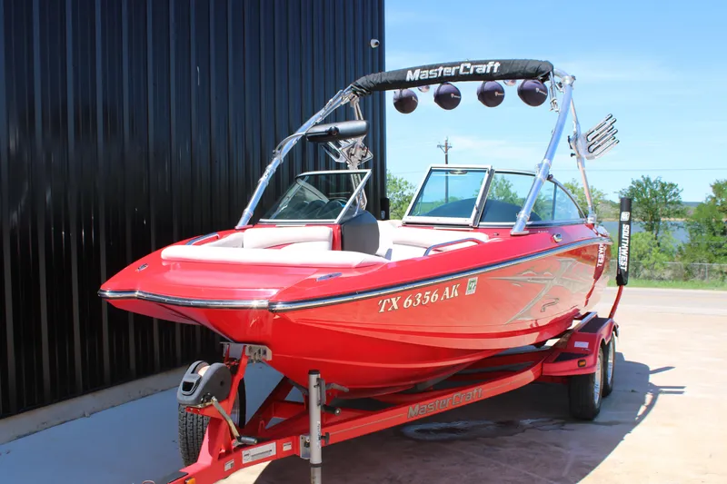 Slide: The Image of Red 2007 MasterCraft X2 boat on trailer, parked outdoors. - 3
