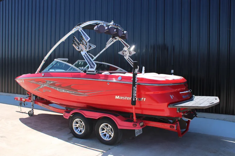 Slide: The Image of 2007 MasterCraft X2 boat in vibrant red on a trailer, parked outdoors. - 5