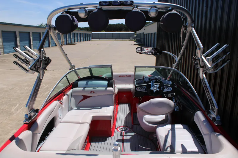 Slide: The Image of 2007 MasterCraft X2 boat interior with red and white seating, sleek dashboard, and wakeboard racks. - 7
