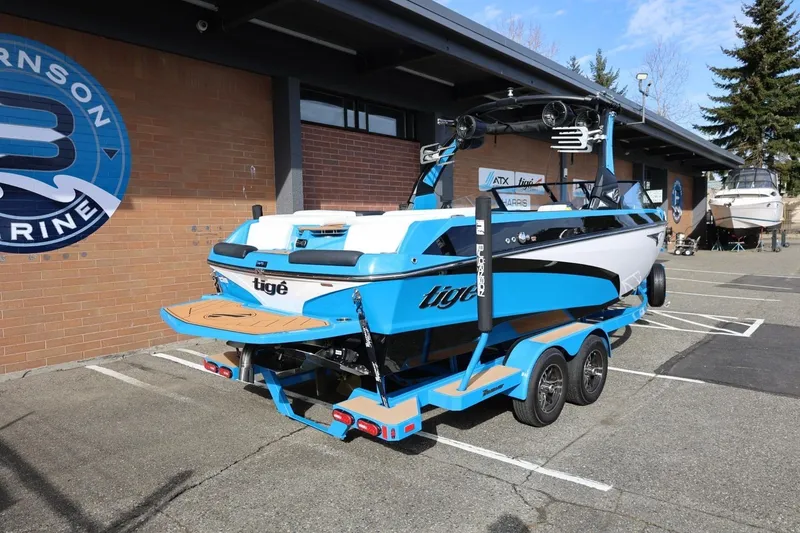 Slide: The Image of 2022 Tigé Z3 boat in vibrant blue, parked outside a marine dealership. - 14