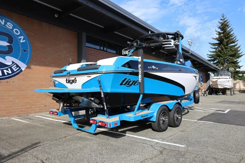 Slide: The Image of 2022 Tigé Z3 boat on trailer, vibrant blue and white design, parked outdoors. - 15