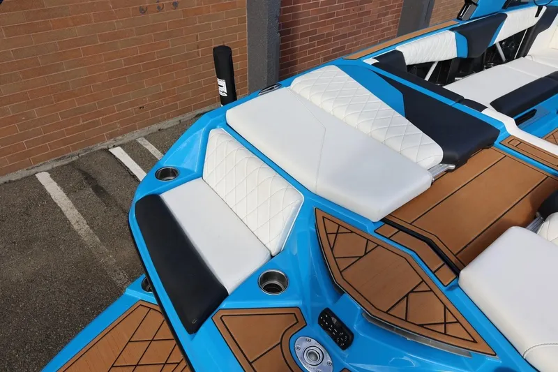 Slide: The Image of 2022 Tigé Z3 boat interior with blue and white seating, brown deck accents. - 16