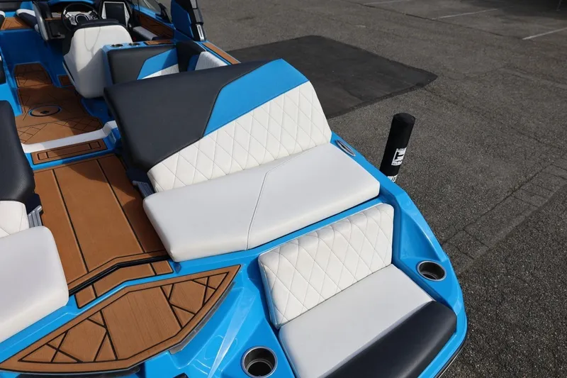Slide: The Image of 2022 Tigé Z3 boat interior with blue and white seating, wood accents, and modern design. - 19