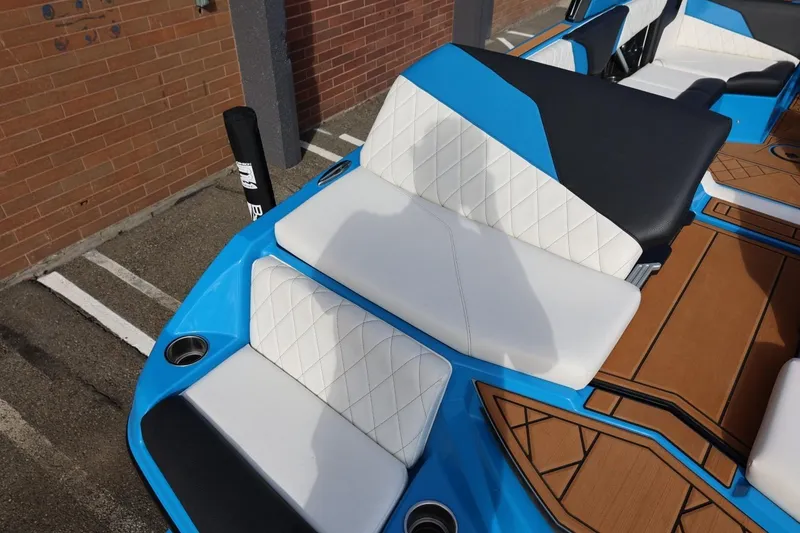 Slide: The Image of 2022 Tigé Z3 boat interior with blue and white seating, featuring diamond stitching and cup holders. - 20