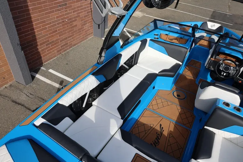 Slide: The Image of 2022 Tigé Z3 boat interior with blue and white seating, brown flooring, and modern dashboard. - 21