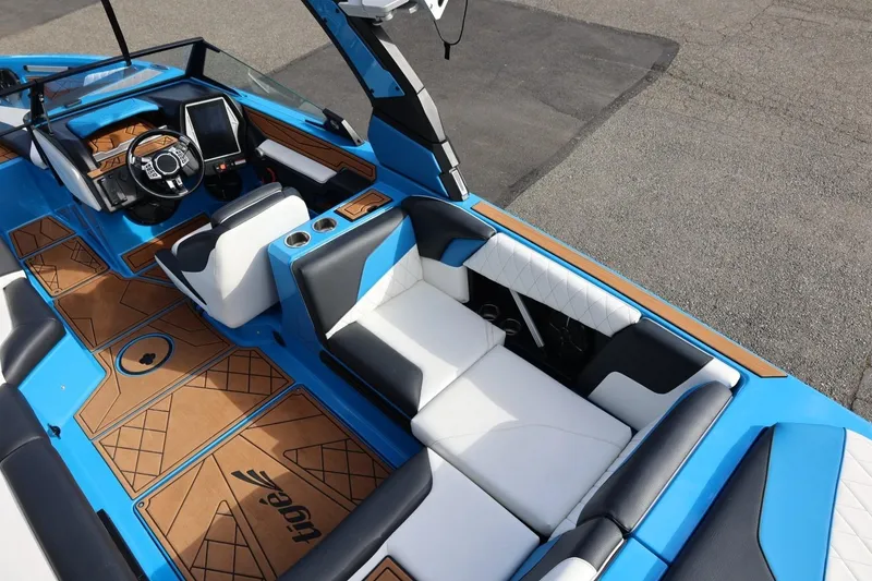Slide: The Image of 2022 Tigé Z3 boat interior with blue and white seating, modern dashboard, and wood accents. - 22