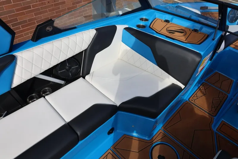 Slide: The Image of 2022 Tigé Z3 boat interior with blue, black, and white seating, featuring cup holders and stylish flooring. - 24
