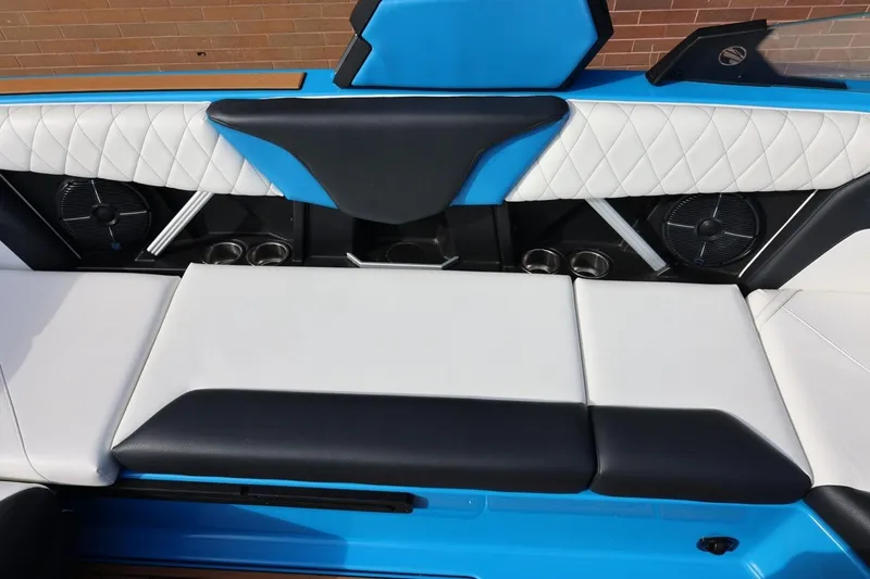 Slide: The Image of 2022 Tigé Z3 boat interior with blue and white seating, featuring cup holders and speakers. - 25
