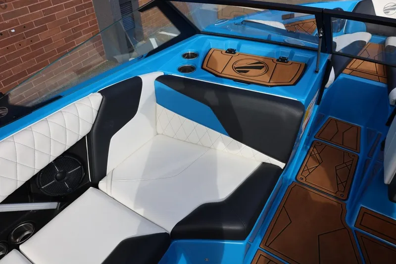 Slide: The Image of 2022 Tigé Z3 boat interior with blue and white seating, brown accents, and cup holders. - 34