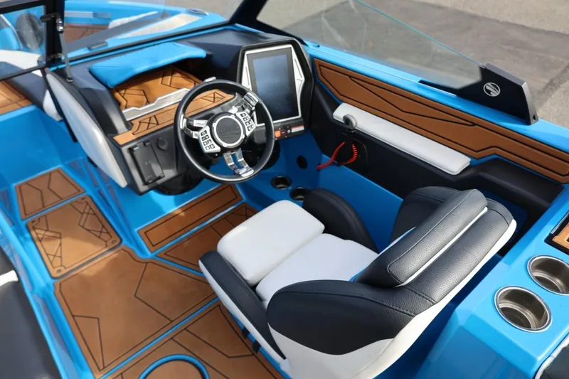 Slide: The Image of 2022 Tigé Z3 boat interior with blue and brown accents, featuring a modern steering wheel and touchscreen. - 36