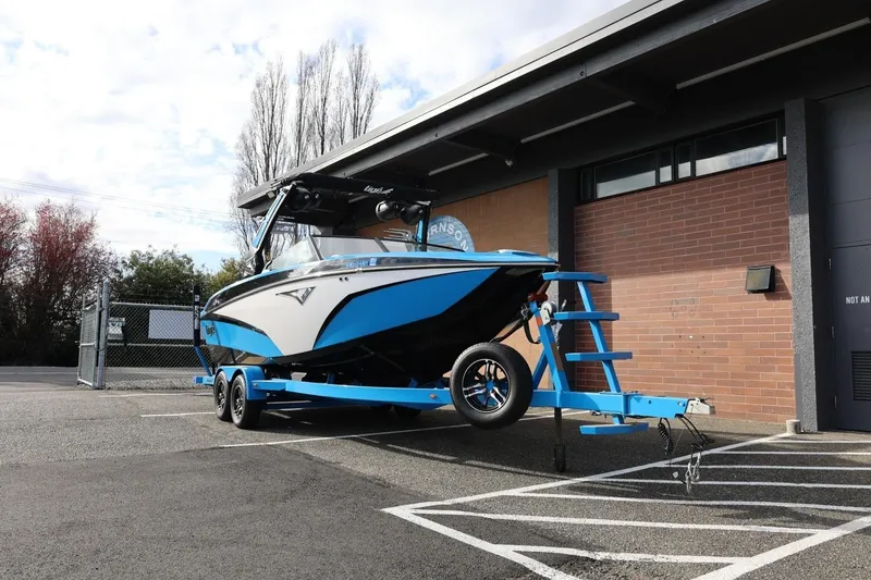 Slide: The Image of 2022 Tigé Z3 boat on trailer, parked outside a brick building. - 4