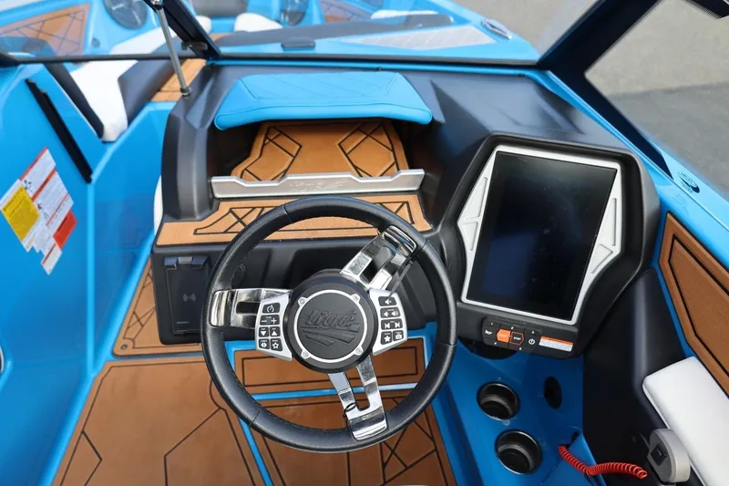 Slide: The Image of 2022 Tigé Z3 boat dashboard with steering wheel and touchscreen display, featuring blue and brown accents. - 45