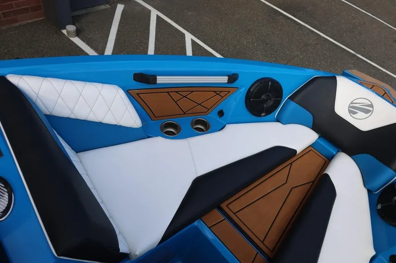 Slide: The Image of 2022 Tigé Z3 boat interior with blue, white, and brown seating, featuring cup holders and speakers. - 47
