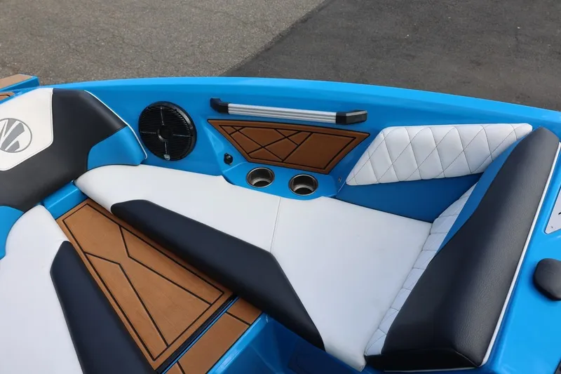 Slide: The Image of 2022 Tigé Z3 boat interior with blue, white, and black seating, featuring wood accents. - 48