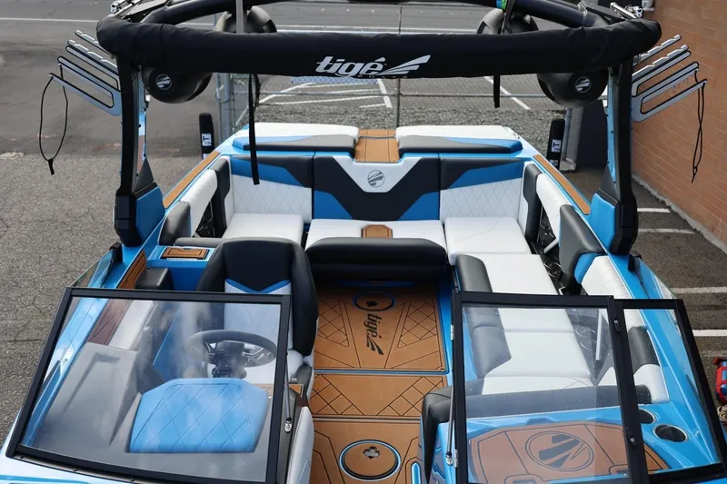 Slide: The Image of 2022 Tigé Z3 boat interior with blue and white seating, steering wheel, and open windshield. - 50