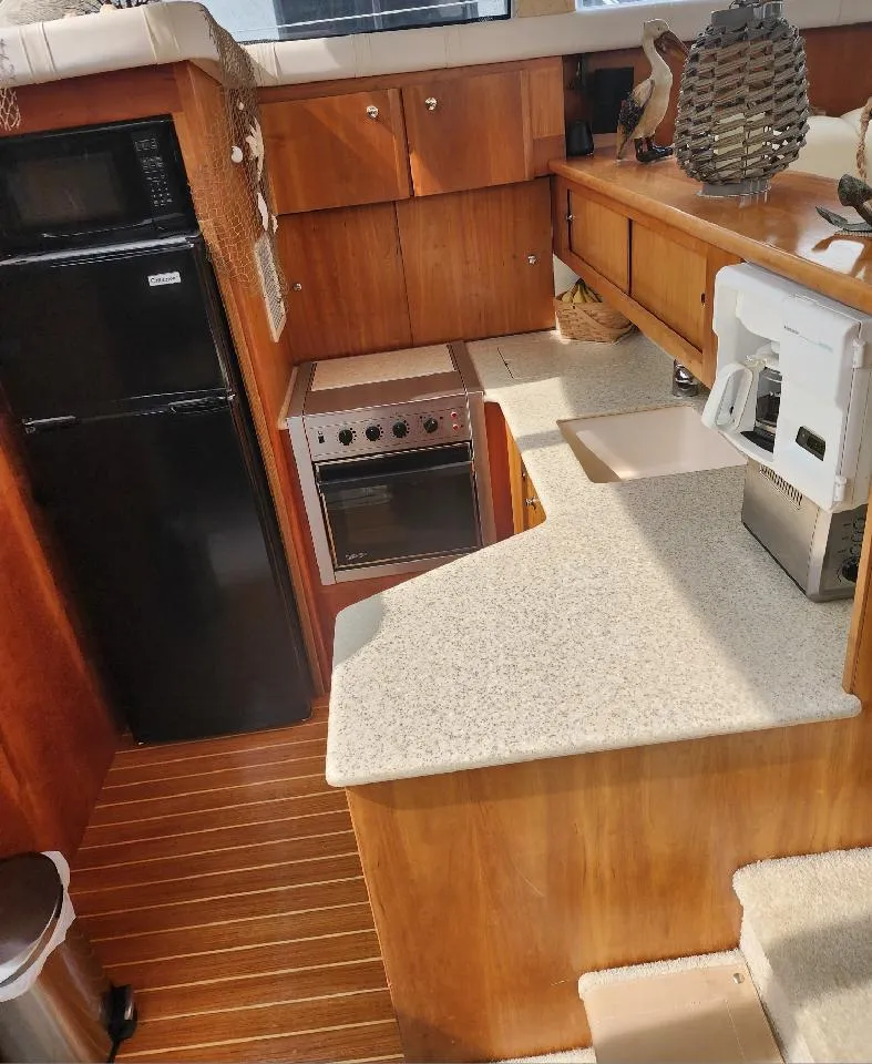 Slide: The Image of Interior of 2000 Silverton 422 Motor Yacht with kitchen and wood paneling. - 13