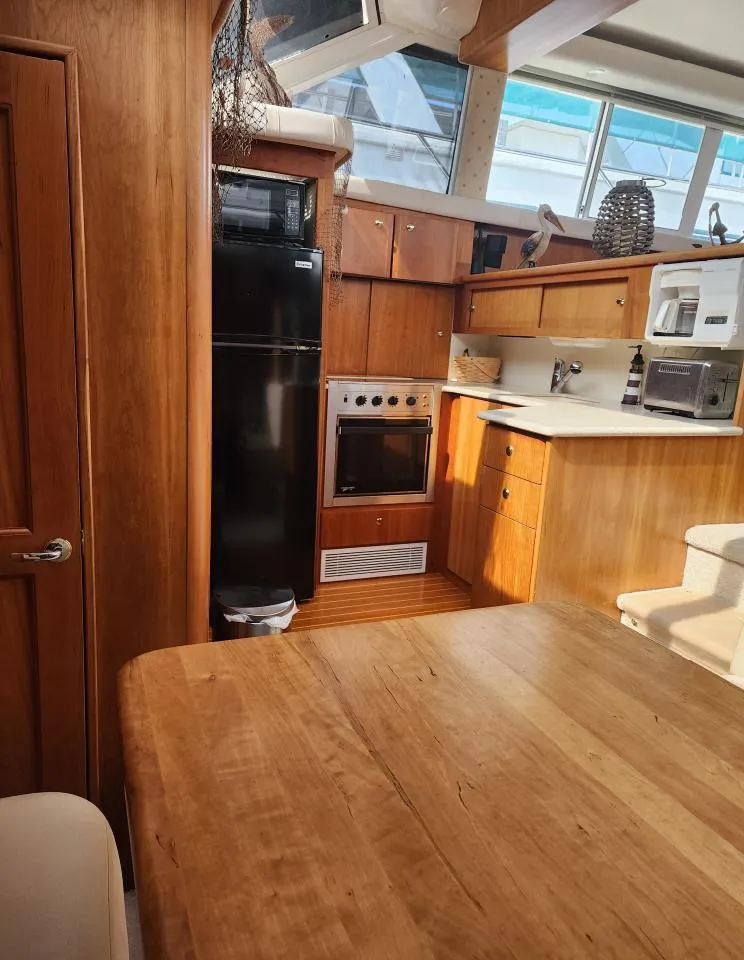 Slide: The Image of Interior of 2000 Silverton 422 Motor Yacht featuring kitchen area. - 14