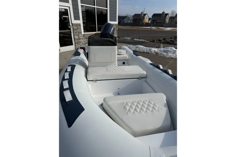 Slide: The Image of 2026 Novurania DL 430 boat with white seating and modern design, parked outdoors. - 3