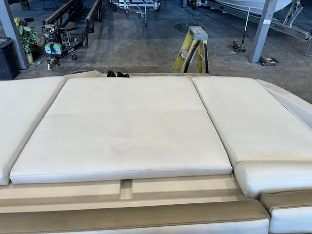 Slide: The Image of 2007 Sea Ray 230 Select boat interior with white cushioned seating in a garage. - 14