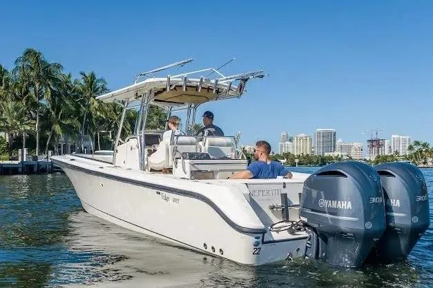 Slide: The Image of 2010 Edgewater 318CC boat with Yamaha engines on a sunny day, city skyline in background. - 10