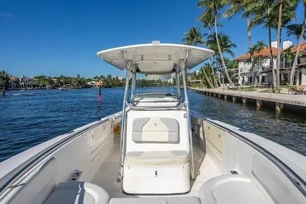 Slide: The Image of 2010 Edgewater 318CC boat on a scenic waterfront with palm trees and luxury homes. - 11