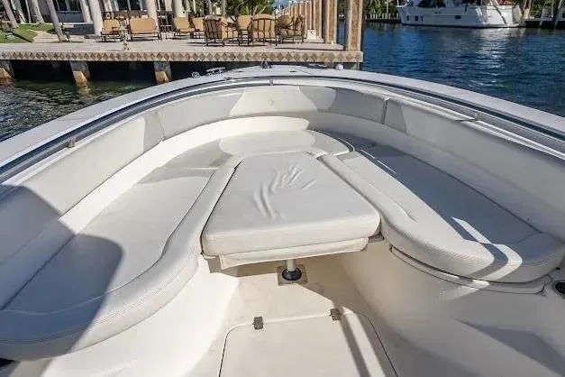 Slide: The Image of 2010 Edgewater 318CC boat interior with cushioned seating near dock. - 12