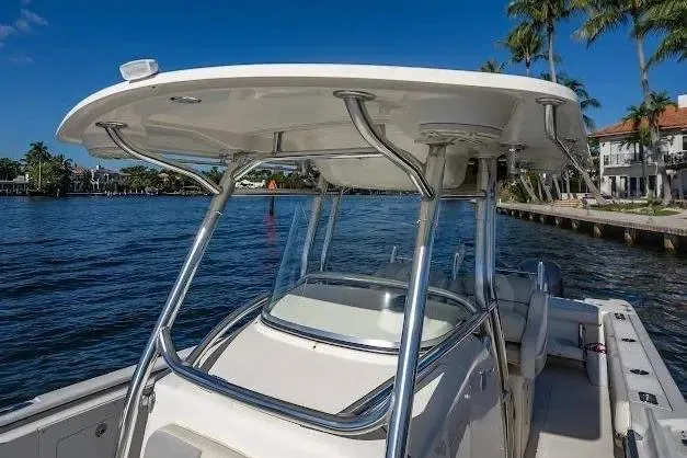 Slide: The Image of 2010 Edgewater 318CC boat on water, featuring sleek design and sturdy T-top. - 13