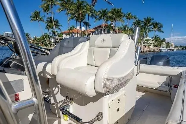 Slide: The Image of 2010 Edgewater 318CC boat interior with plush seating, palm trees, and waterfront view. - 14
