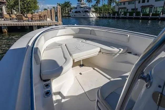 Slide: The Image of 2010 Edgewater 318CC boat interior with seating, docked near waterfront homes. - 19