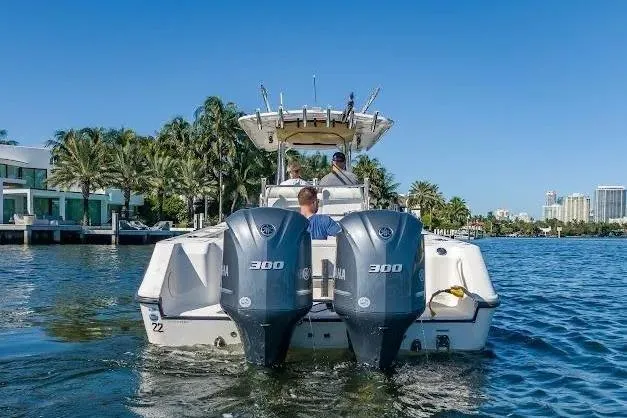 Slide: The Image of 2010 Edgewater 318CC boat with dual Yamaha 300 engines on a sunny waterfront. - 21