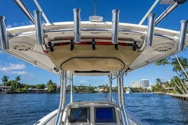 Slide: The Image of 2010 Edgewater 318CC boat on water, featuring T-top and rod holders. - 23