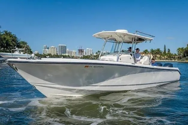 Slide: The Image of 2010 Edgewater 318CC boat cruising on a sunny day near a city skyline. - 5