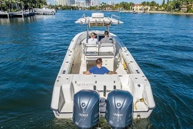 Slide: The Image of 2010 Edgewater 318CC boat cruising on a scenic waterway with three passengers. - 7