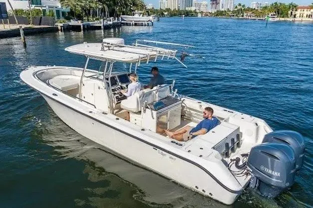 Slide: The Image of 2010 Edgewater 318CC boat cruising on a sunny day with three passengers. - 8